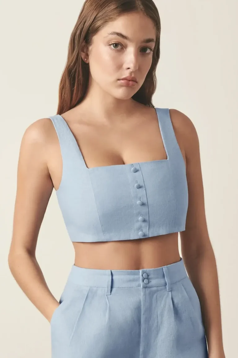 Front view of blue linen crop top with square neckline and covered buttons.